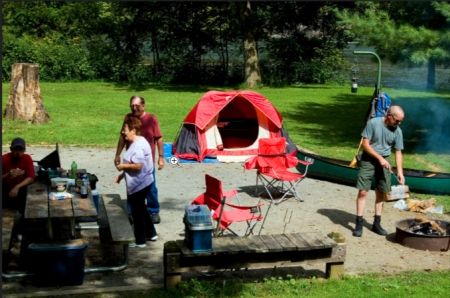 a group of people preparing dinner at a campsite